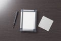 Empty, beautiful, photo frame and empty white paper cards for entries stylish corporate pen on a dark wood Desk.